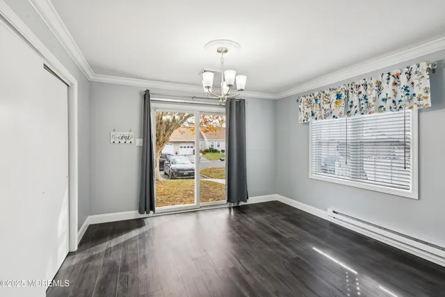 a view of a hallway with wooden floor and a kitchen