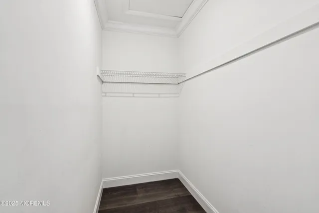 an empty room with wooden floor and ceiling fan