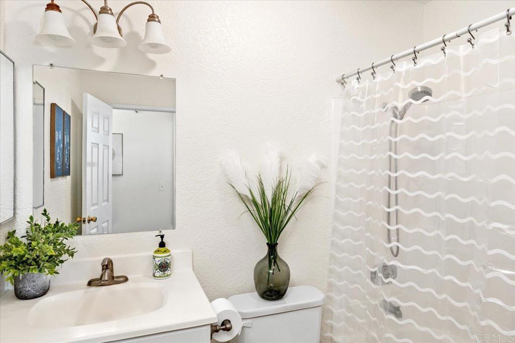 868 East Alvarado Street, Unit 27 Fallbrook, CA 92028 - Photo 13 of 20 a bathroom with a sink a potted plant and a shower curtain