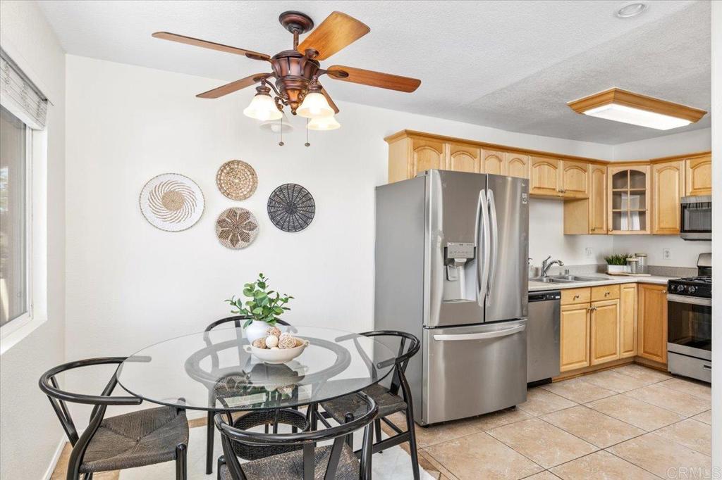 868 East Alvarado Street, Unit 27 Fallbrook, CA 92028 - Photo 4 of 20 a kitchen with stainless steel appliances granite countertop a dining table chairs stove and white cabinets
