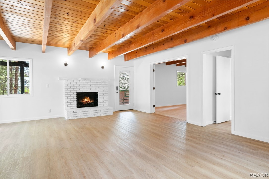 39596 Forest Road Big Bear Lake, CA 92315 - Photo 23 of 50 a view of an empty room with wooden floor and a fireplace