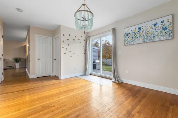 a view of a hallway with wooden floor and chandelier