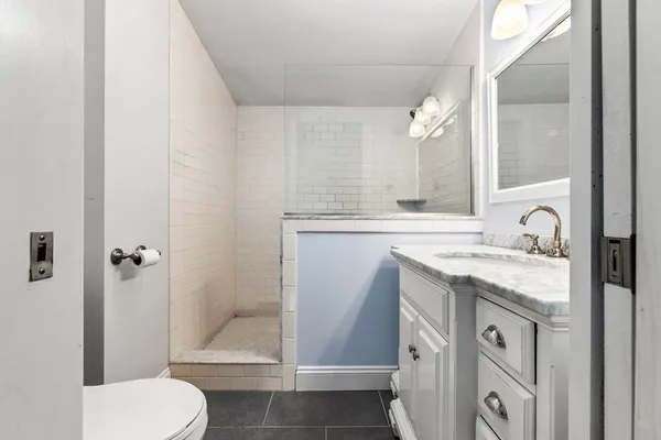 a bathroom with a granite countertop sink toilet and shower