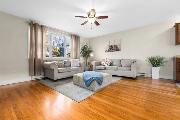 a living room with furniture and a large window with wooden floor