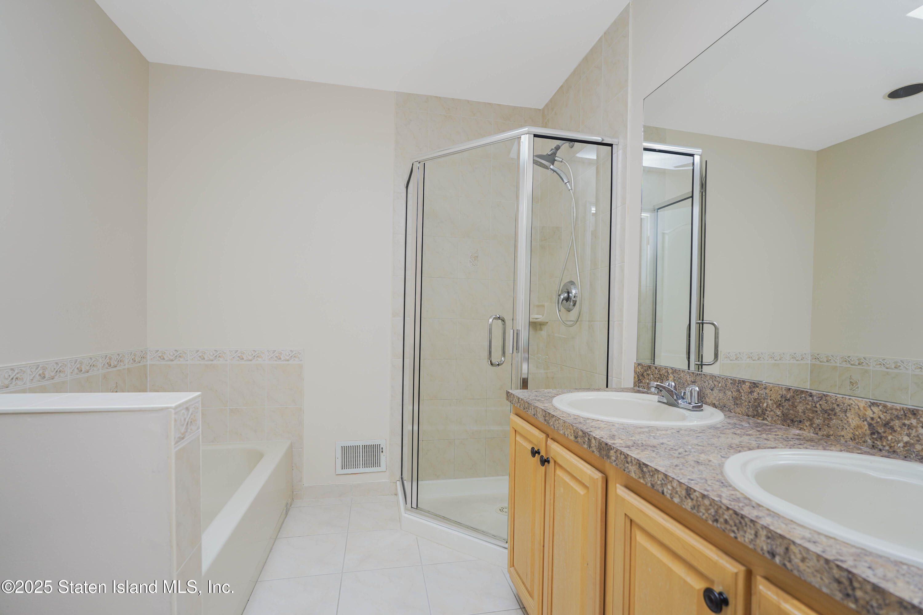 119 Glenn Road Staten Island, NY 10314 - Photo 14 of 26 a bathroom with a granite countertop sink a mirror and a bathtub