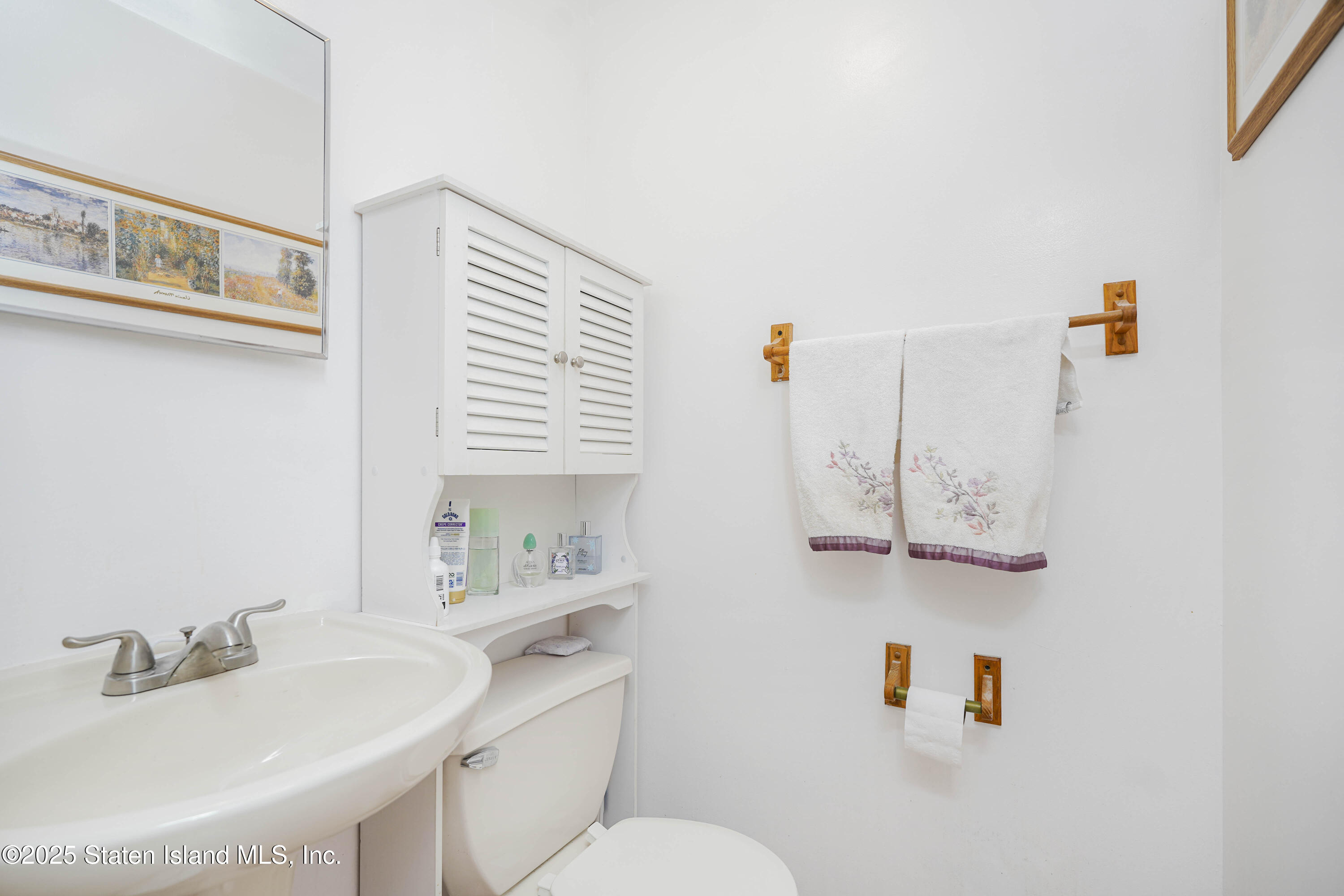 119 Glenn Road Staten Island, NY 10314 - Photo 9 of 26 a bathroom with a sink toilet and a mirror
