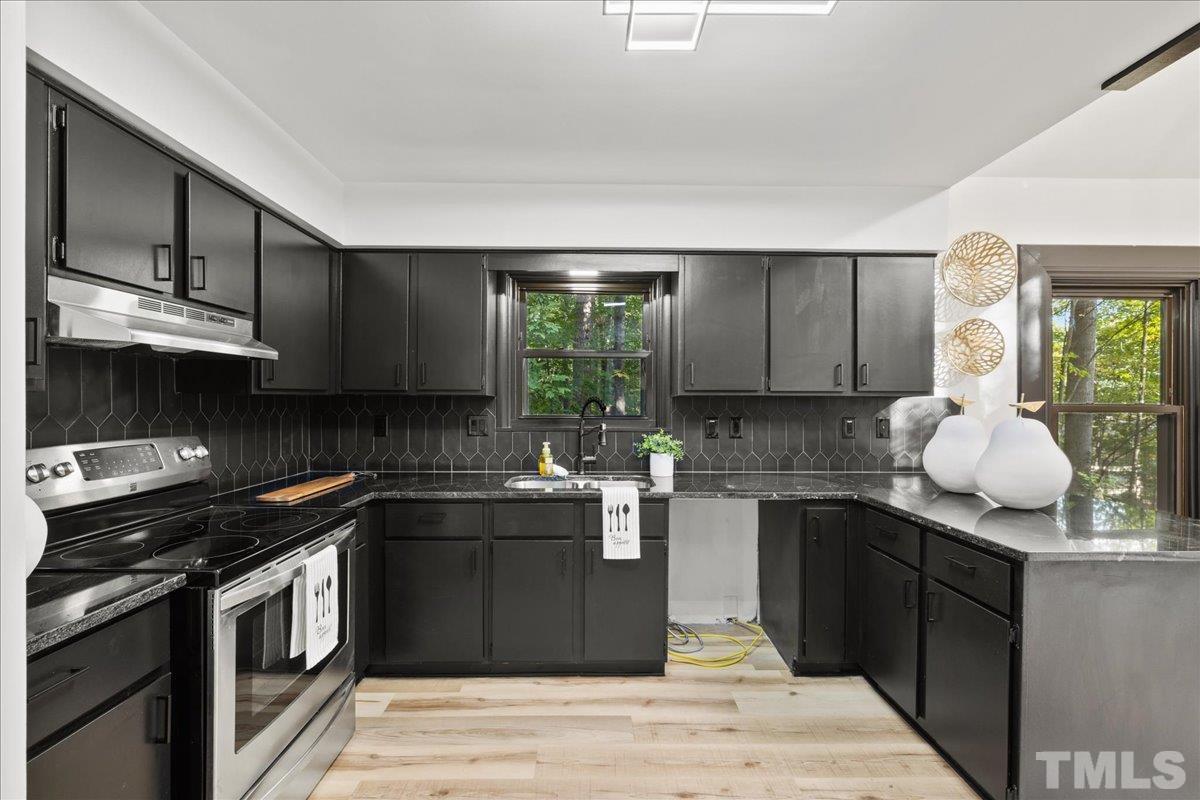 5816 Shannas Way Durham, NC 27713 - Photo 11 of 40 a kitchen with stainless steel appliances granite countertop a sink stove and microwave