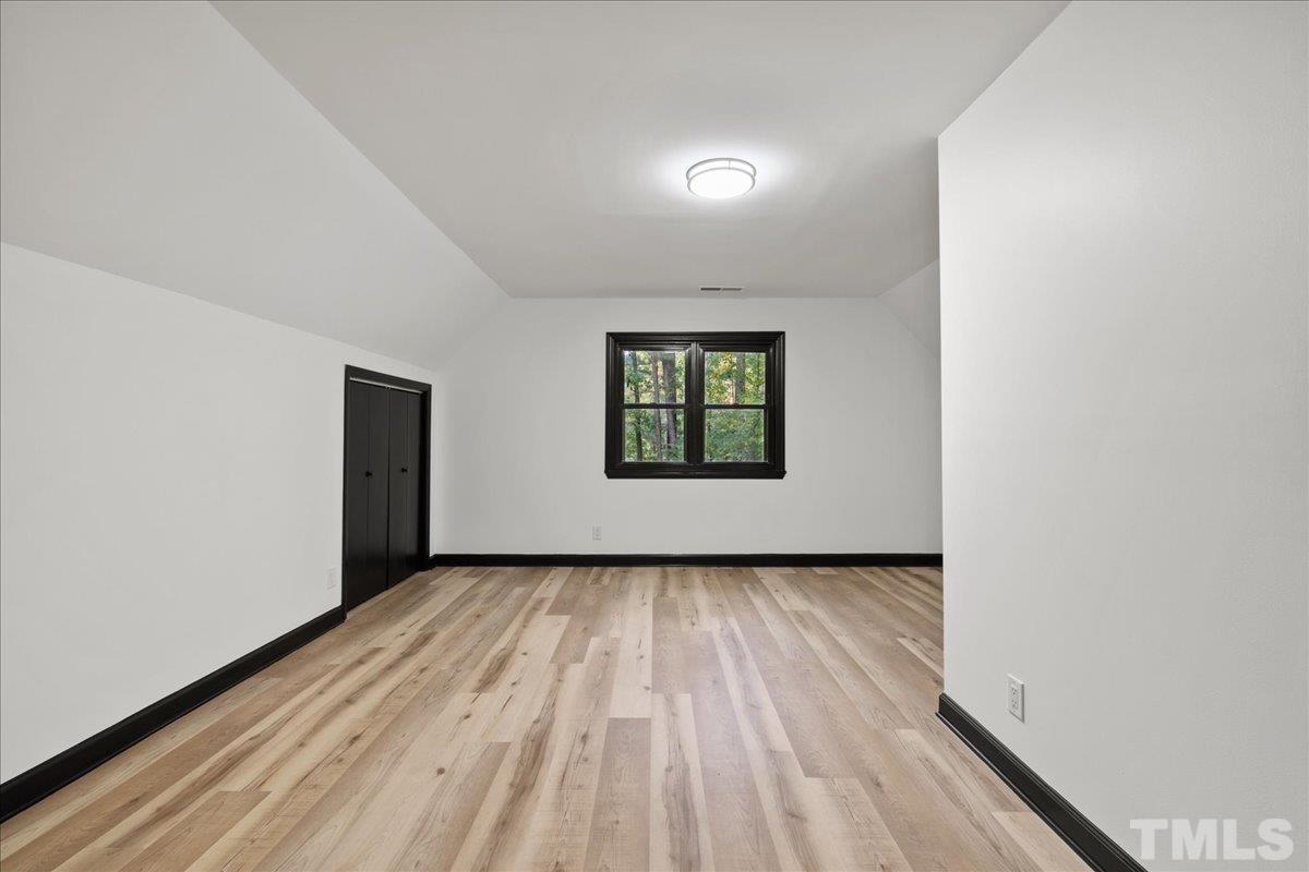 5816 Shannas Way Durham, NC 27713 - Photo 23 of 40 an empty room with wooden floor white walls and windows