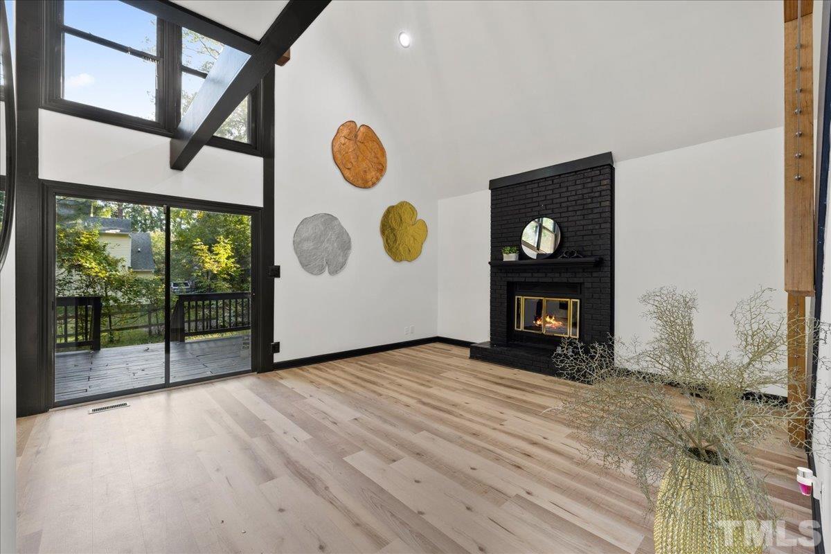 5816 Shannas Way Durham, NC 27713 - Photo 4 of 40 a view of an empty room with wooden floor and windows