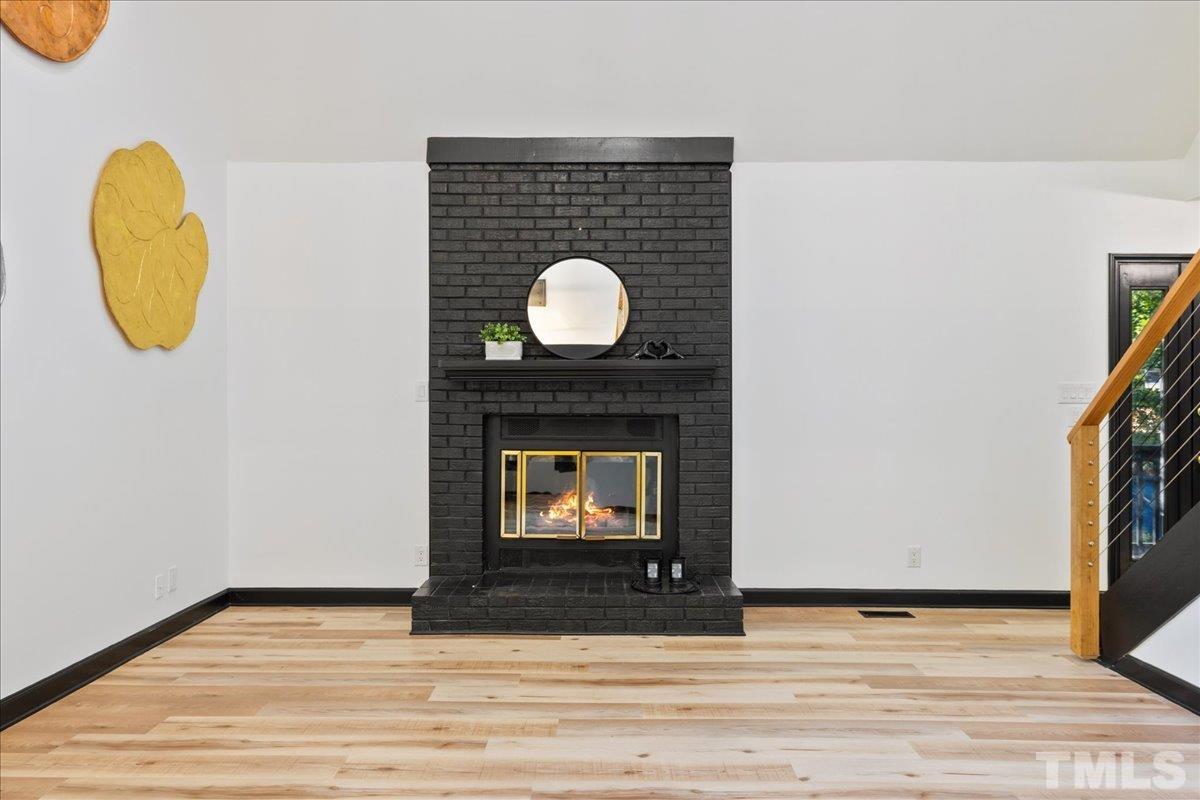 5816 Shannas Way Durham, NC 27713 - Photo 5 of 40 a view of a fireplace with wooden floor