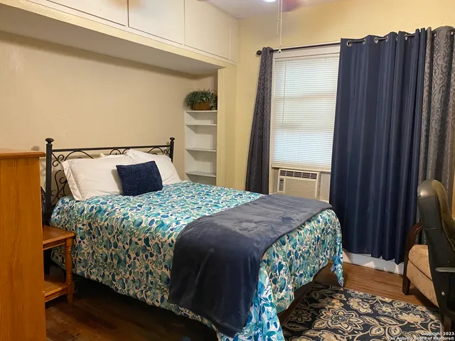 a bedroom with a bed and wooden floor