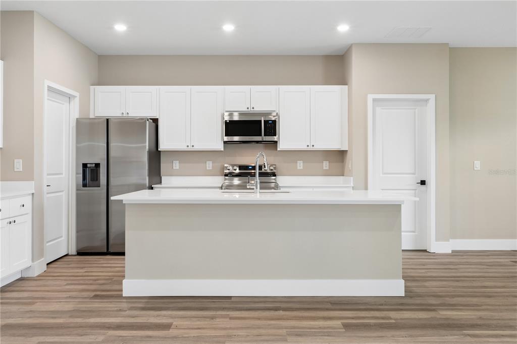 21 Postman Lane Palm Coast, FL 32164 - Photo 4 of 13 a view of kitchen with stainless steel appliances granite countertop a refrigerator a sink and white cabinets