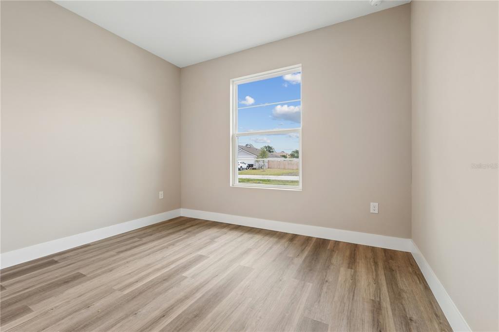 21 Postman Lane Palm Coast, FL 32164 - Photo 9 of 13 an empty room with wooden floor and windows