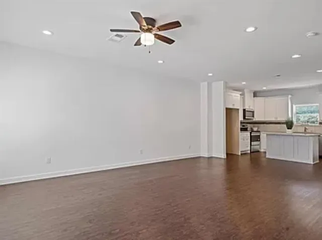 wooden floor in an empty room with a kitchen