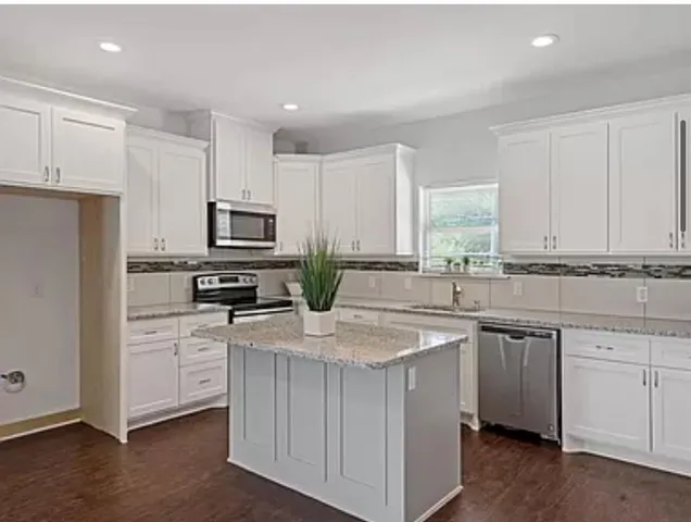 a kitchen with white cabinets sink and stainless steel appliances