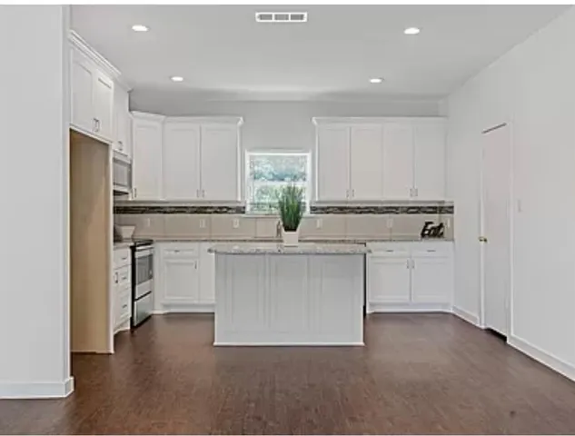 a kitchen with white cabinets and appliances