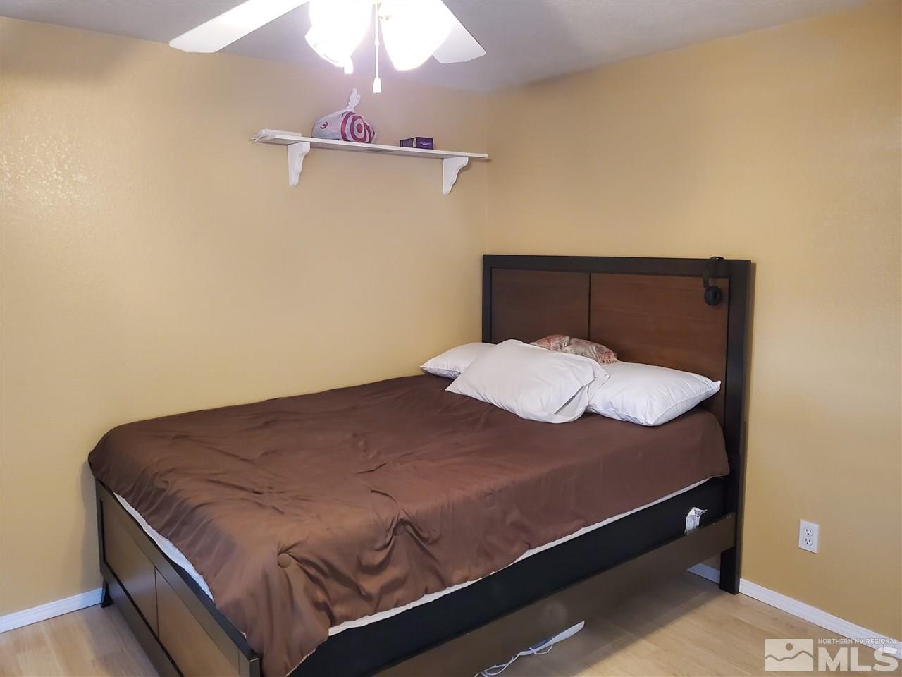 2146 Barberry Way Reno, NV 89512 - Photo 7 of 18 a bed sitting in a bedroom next to a lamp