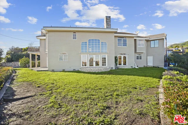 a view of an empty room with wooden floor and windows