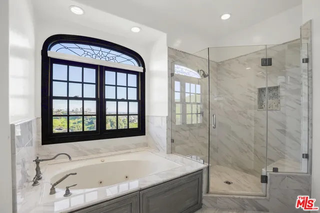 a view of an empty room with wooden floor fireplace and a window
