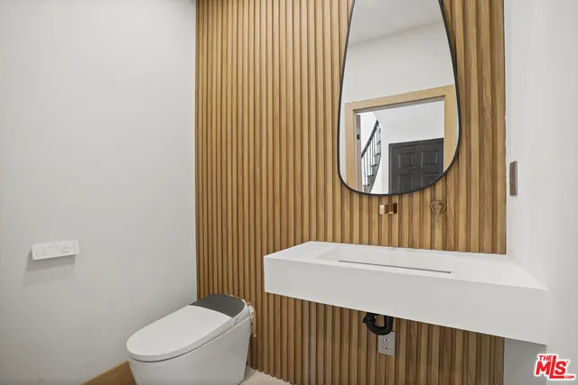 a bathroom with a toilet a sink and mirror