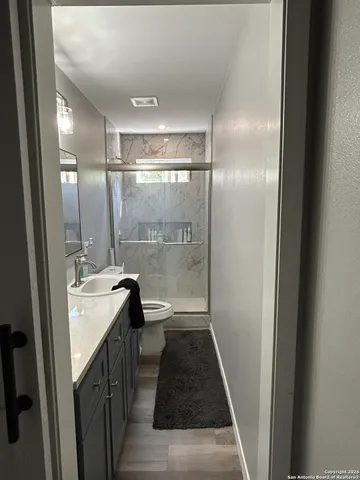 a bathroom with a double vanity sink toilet and shower