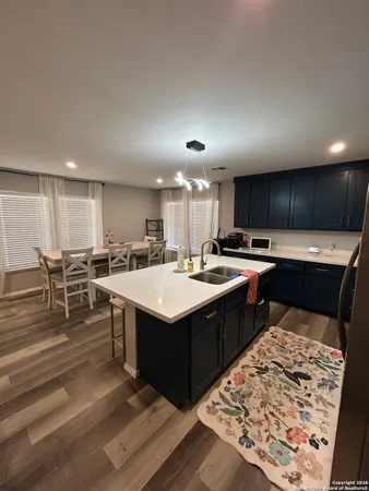 a kitchen with kitchen island granite countertop a sink and a oven