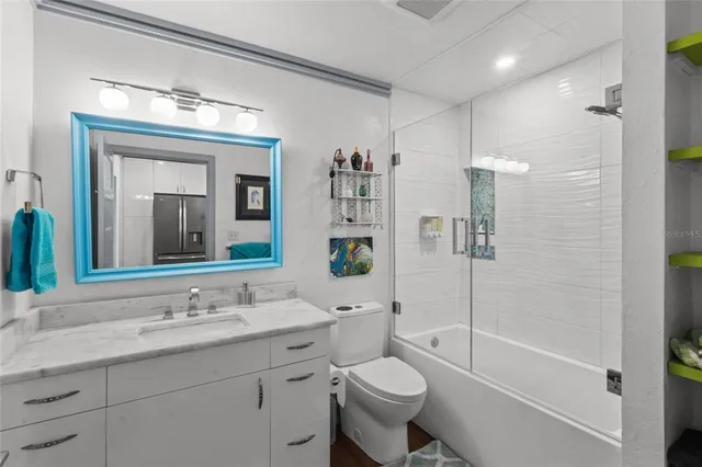 a bathroom with a granite countertop toilet a sink and a bathtub