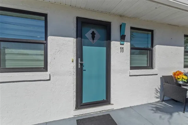 a view of a door and chair in front of the house