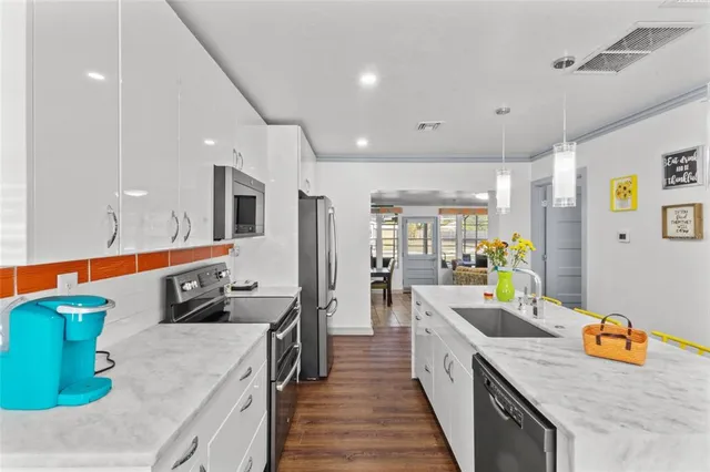 a kitchen with stainless steel appliances granite countertop a sink and a refrigerator