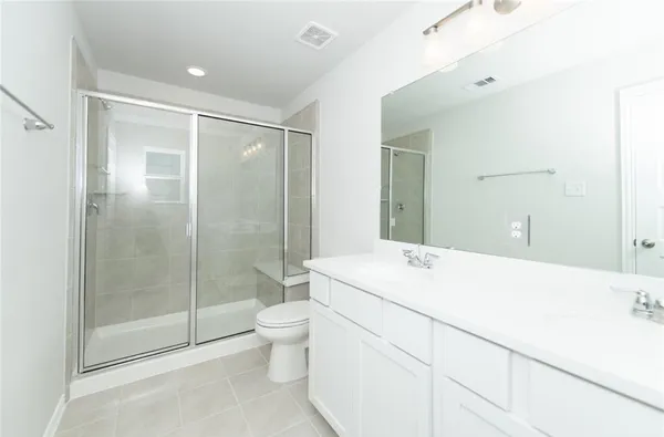 a spacious bathroom with a shower sink mirror and toilet