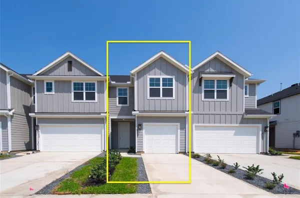 a front view of a house with yard and parking