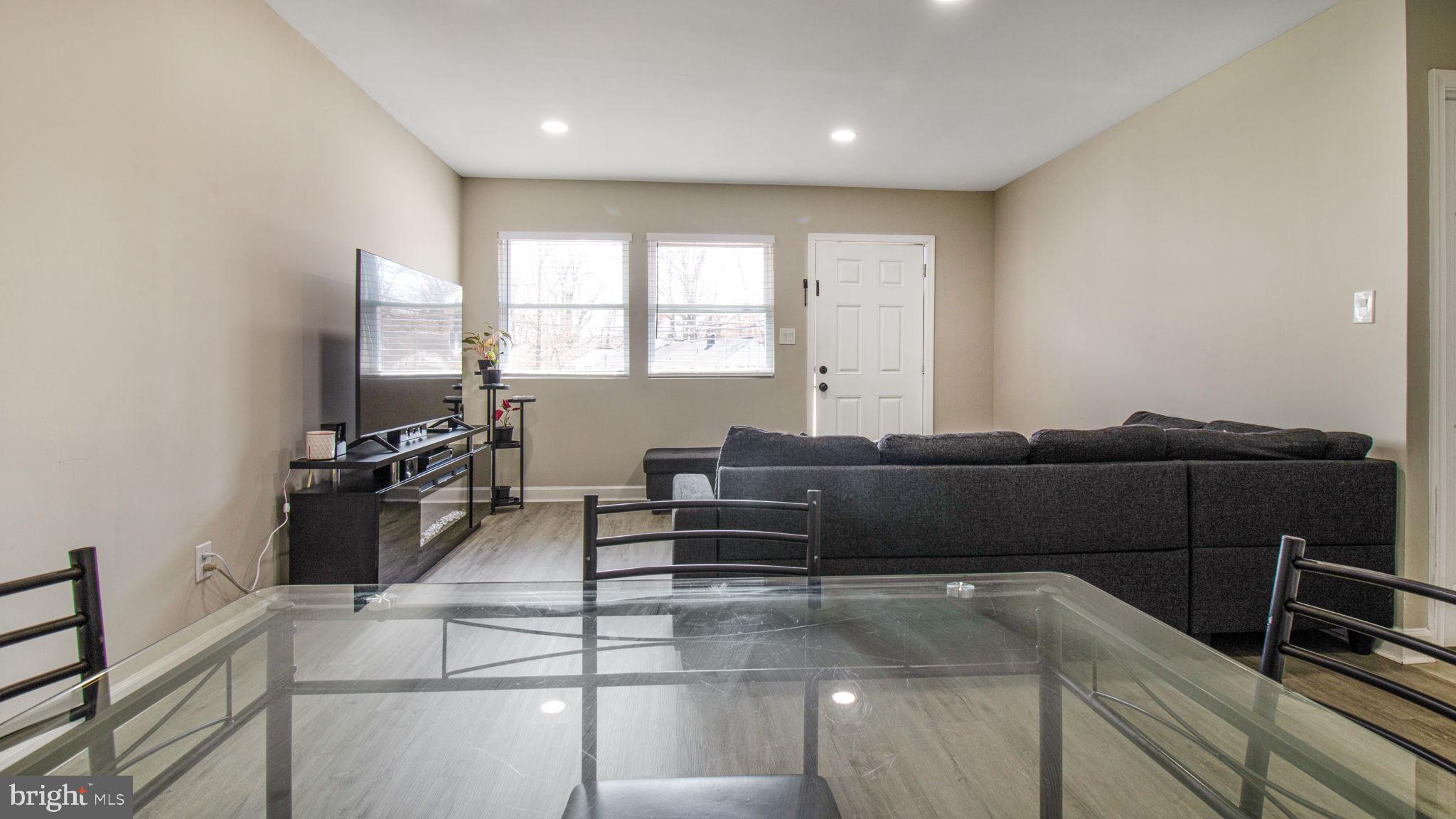 7600 Greenleaf Road Hyattsville, MD 20785 - Photo 9 of 42 a living room with furniture a flat screen tv and a large window