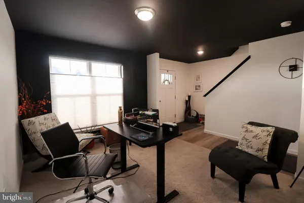 a view of a workspace with furniture and a window