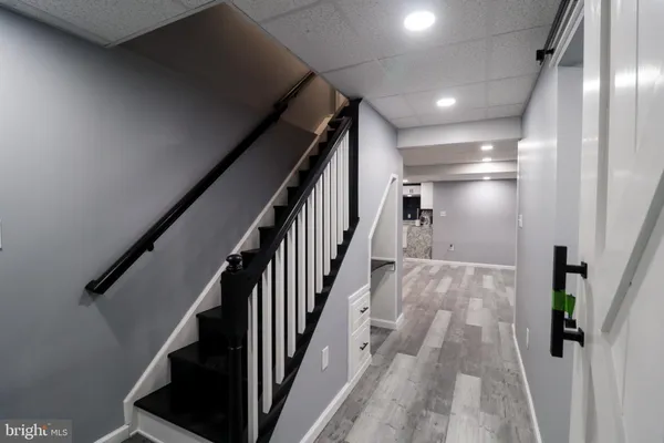 a view of staircase with lots of frames on wall and wooden floor