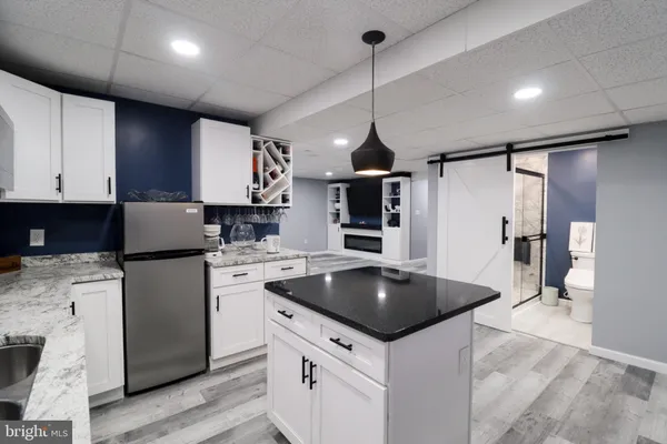 a kitchen with stainless steel appliances granite countertop a sink a stove a refrigerator and island