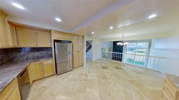 a large kitchen with large window and stainless steel appliances