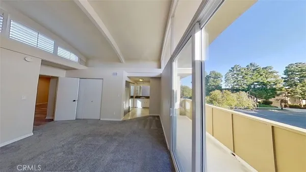 a view of a hallway with wooden floor and a living room