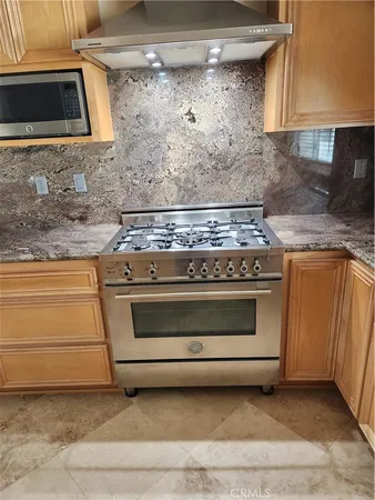 a stove top oven sitting inside of a kitchen