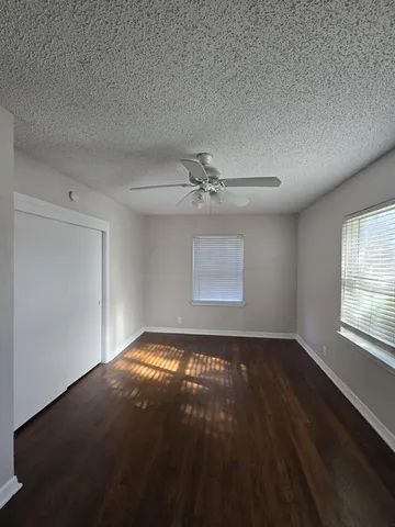 an empty room with windows and ceiling fan view