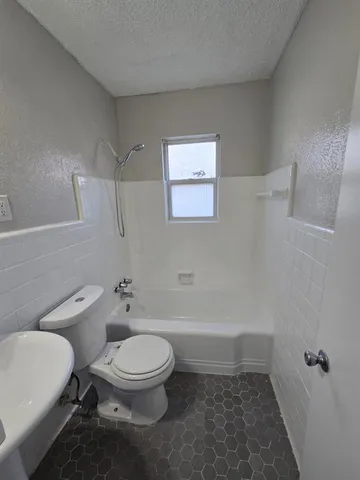 a white toilet sitting next to a bath tub