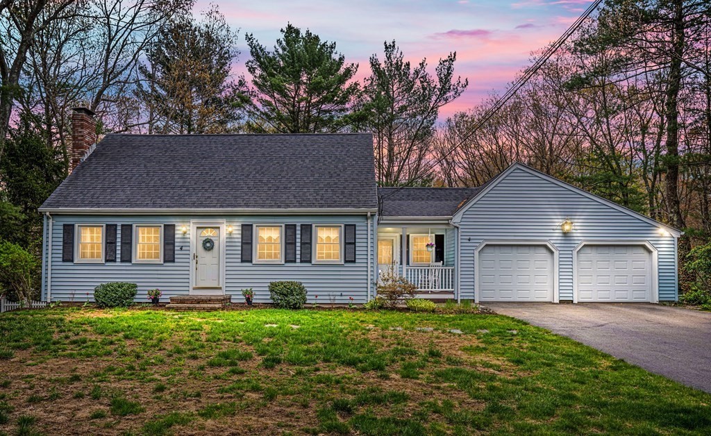 a front view of a house with a yard and trees