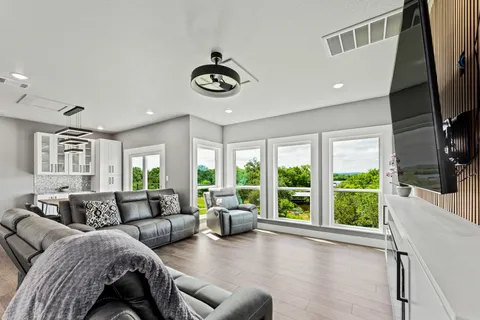 a living room with furniture large window and flat screen tv