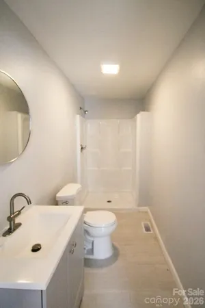 a bathroom with a sink a toilet and a mirror