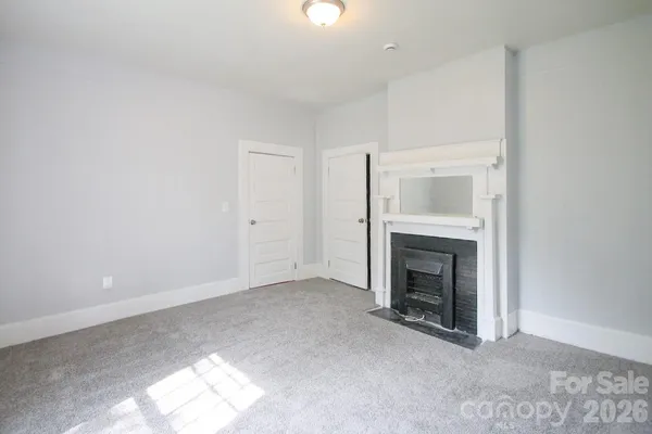 an empty room with a fireplace and window