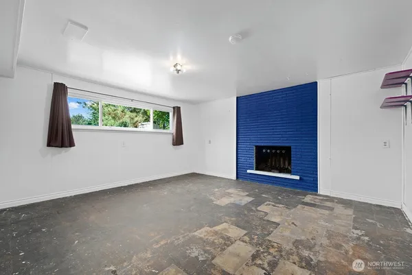 a view of an empty room with a fireplace and a window
