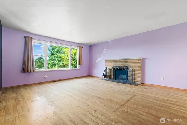 a view of empty room with window and fireplace