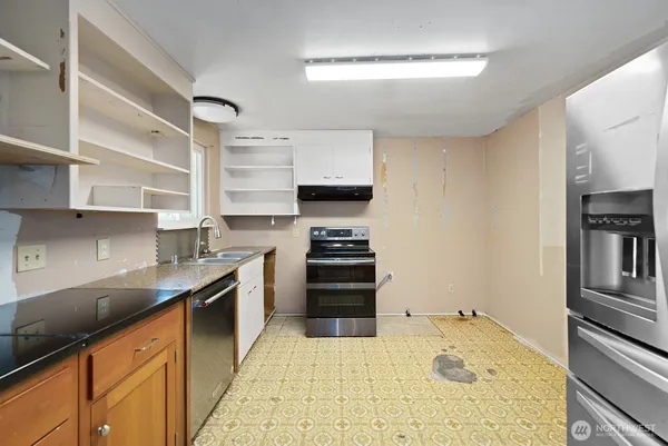 a kitchen with stainless steel appliances granite countertop a sink stove and cabinets