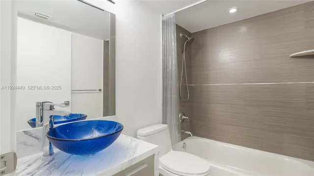 a bathroom with a granite countertop toilet sink and shower