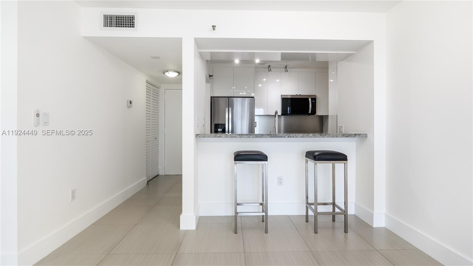 850 North Miami Avenue, Unit W1707 Miami, FL 33136 - Photo 6 of 35 a kitchen with stainless steel appliances kitchen island microwave and cabinets