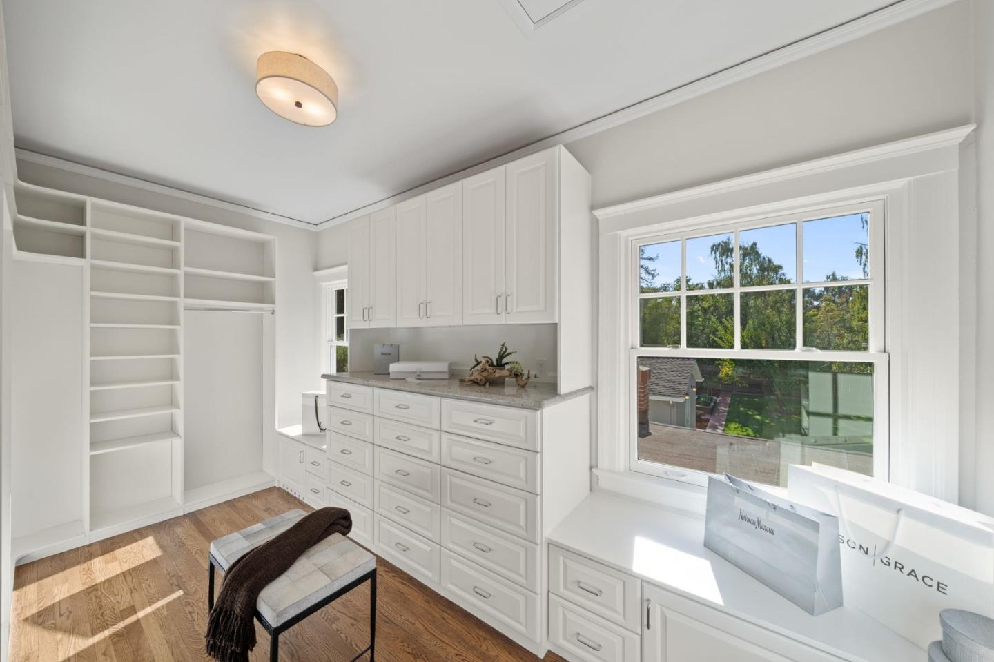 445 Hillcrest Road San Mateo, CA 94402 - Photo 26 of 41 a kitchen with granite countertop a stove and white cabinets with wooden floor